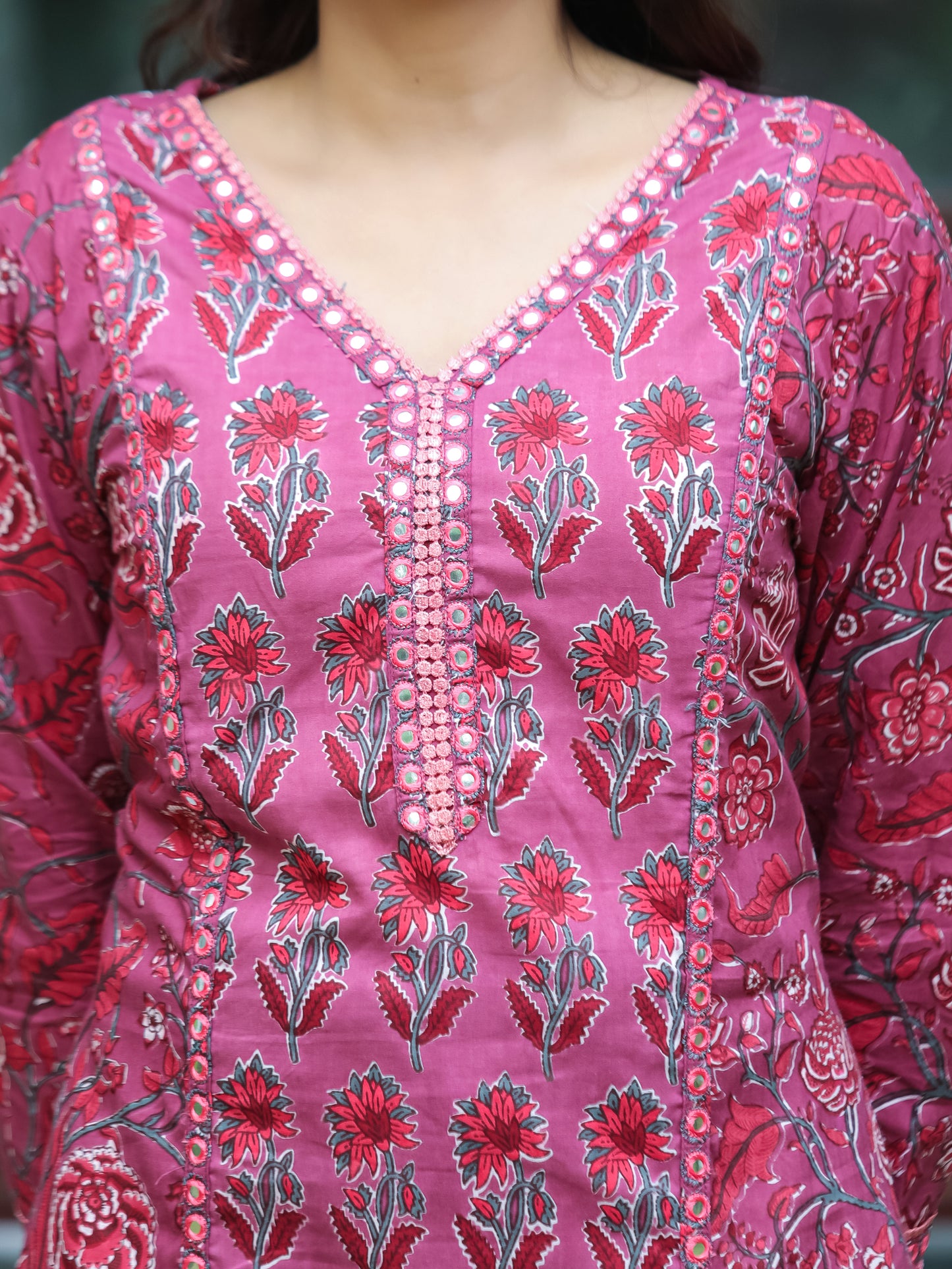 Close-up of the V-neckline on the Dark Fuschia Mirror Work Cotton Suit by Cottons Daily, highlighting the delicate mirror and lace embellishments on the soft cotton fabric, offering a blend of traditional craftsmanship and modern design.