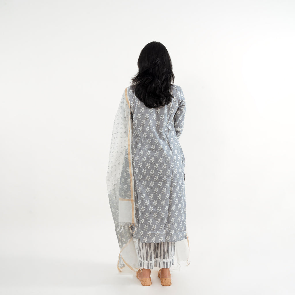 Pant and Dupatta Details: Focus on the white printed straight-fit pants paired with the Chanderi white floral print dupatta featuring a golden border, complementing the kurta in the Floral Grey with Lace Work Striped Pant Cotton Suit by Cottons Daily.