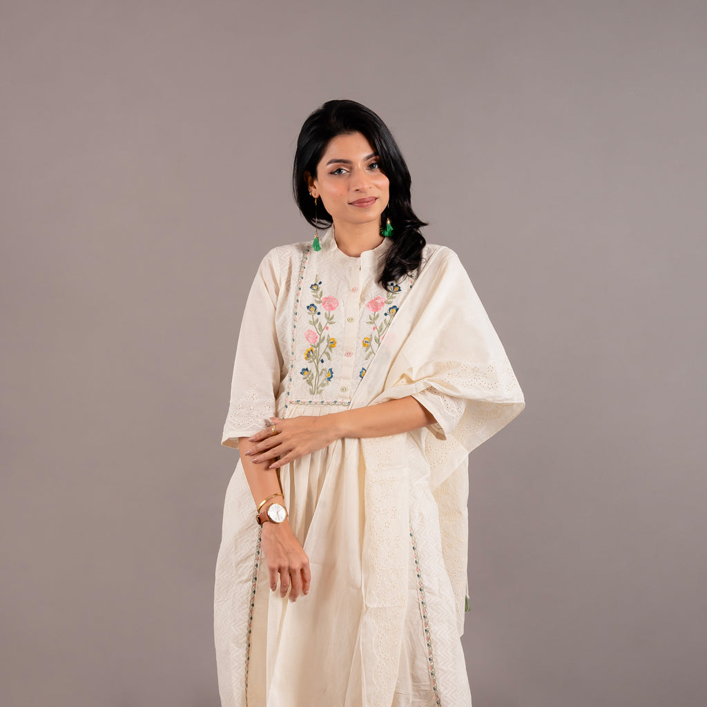The cotton dupatta with tassels from the Off White Floral Cotton Suit, measuring 65 by 15 inches, draped gracefully by the model.
