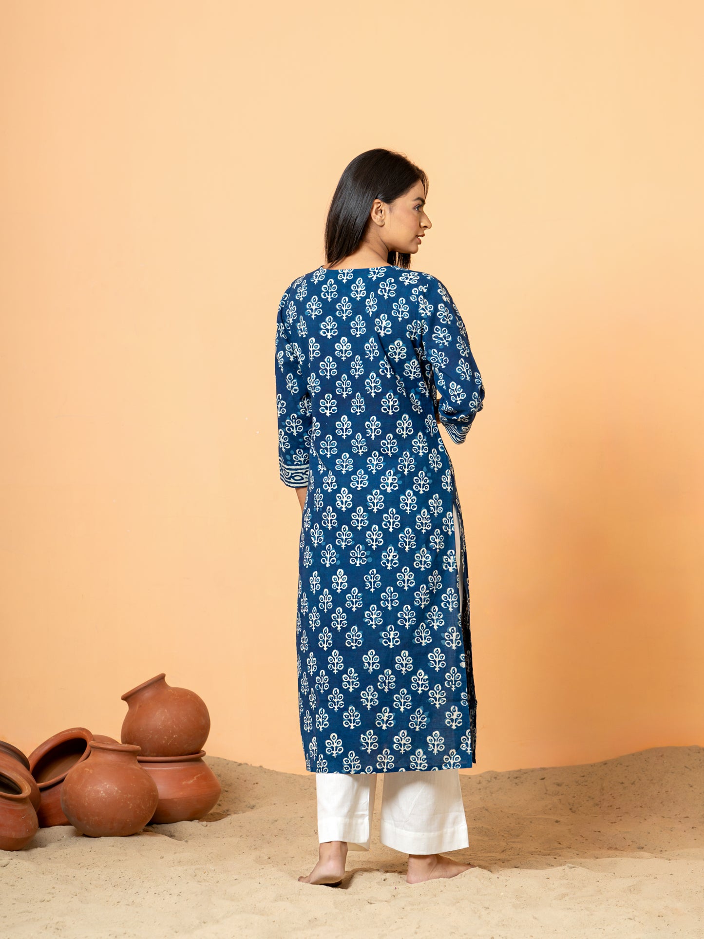 Back view the soft pure cotton fabric and intricate details, possibly including hem or side details, of the Indigo Peacock Feather Print Cotton Kurta.