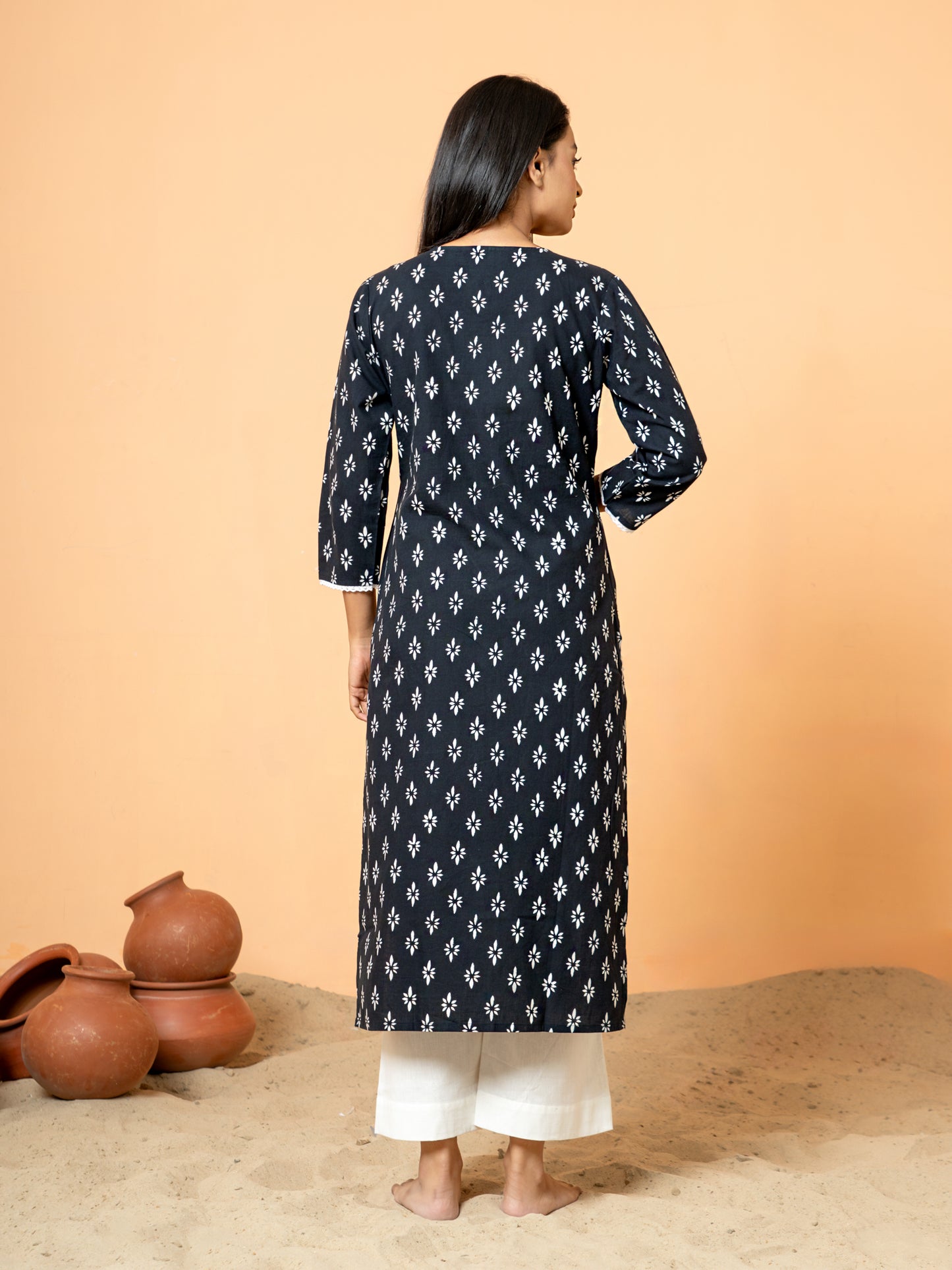 Back view showing the intricate rangoli print, sequence, and lace work near the hem or side slit of the sophisticated Black Sequence Work Cotton Kurta.
