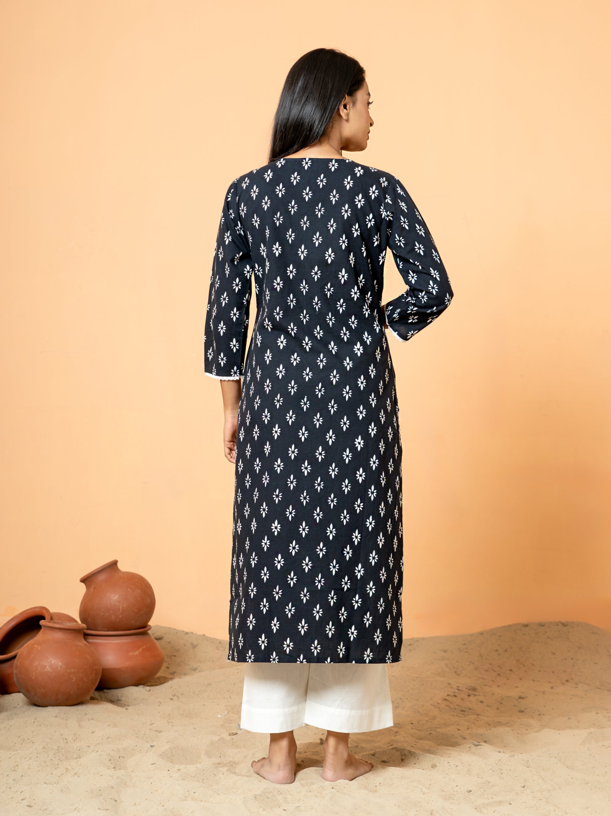 Back view showing the intricate rangoli print, sequence, and lace work near the hem or side slit of the sophisticated Black Sequence Work Cotton Kurta.