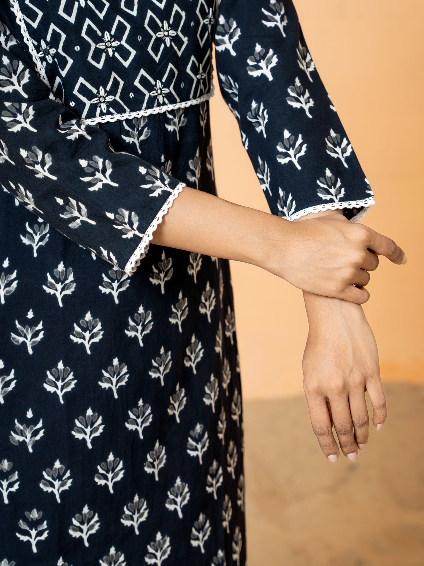 Close-up detail showing the delicate lace work and elegant leaf print on the black cotton fabric of the Black Leaf Print Lace Work Cotton Kurta.