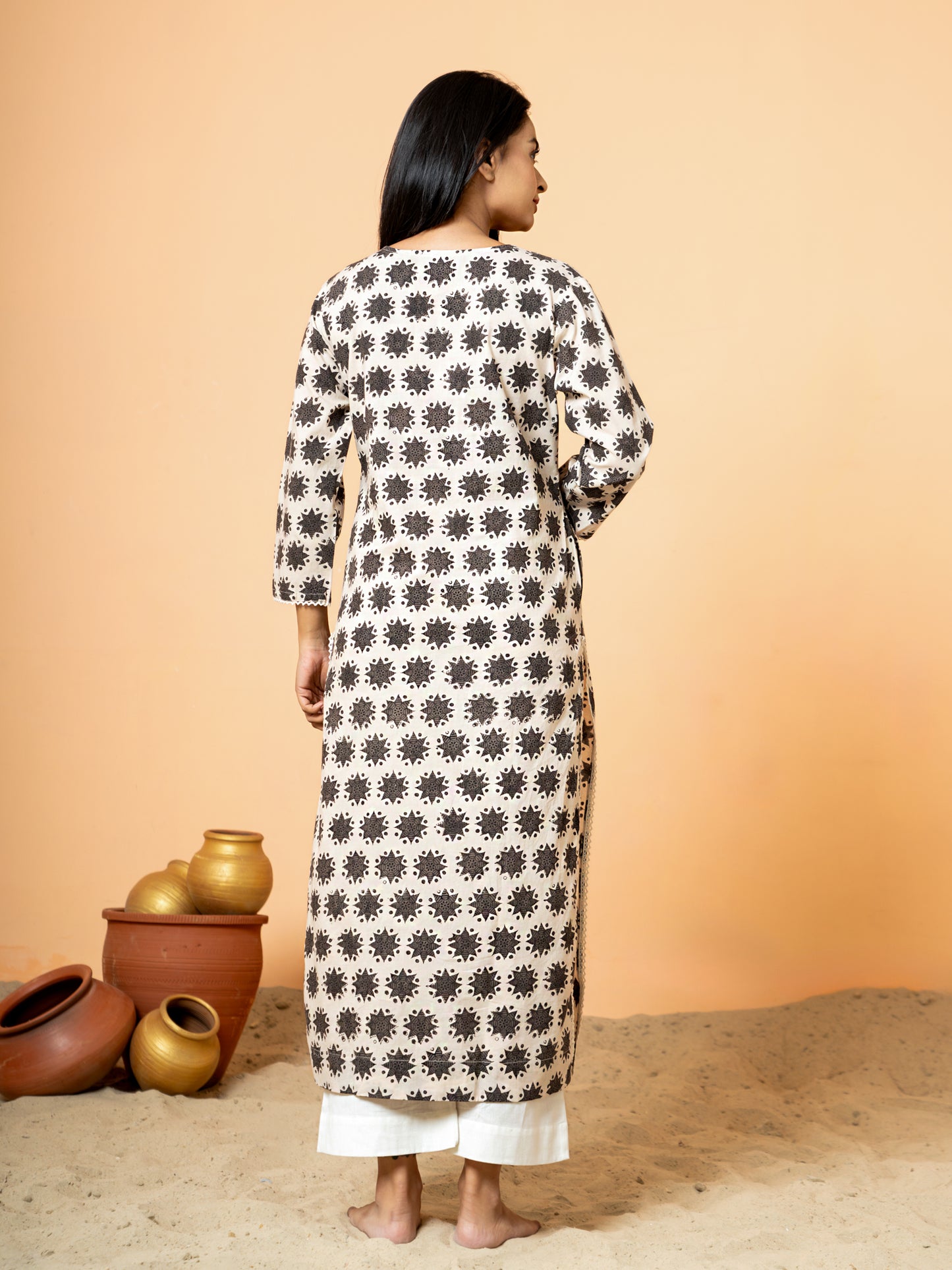 Back view of the Cream Embroidered Rangoli Print Cotton Kurta, giving a sense of the garment's fit and flow with the embroidered rangoli print.
