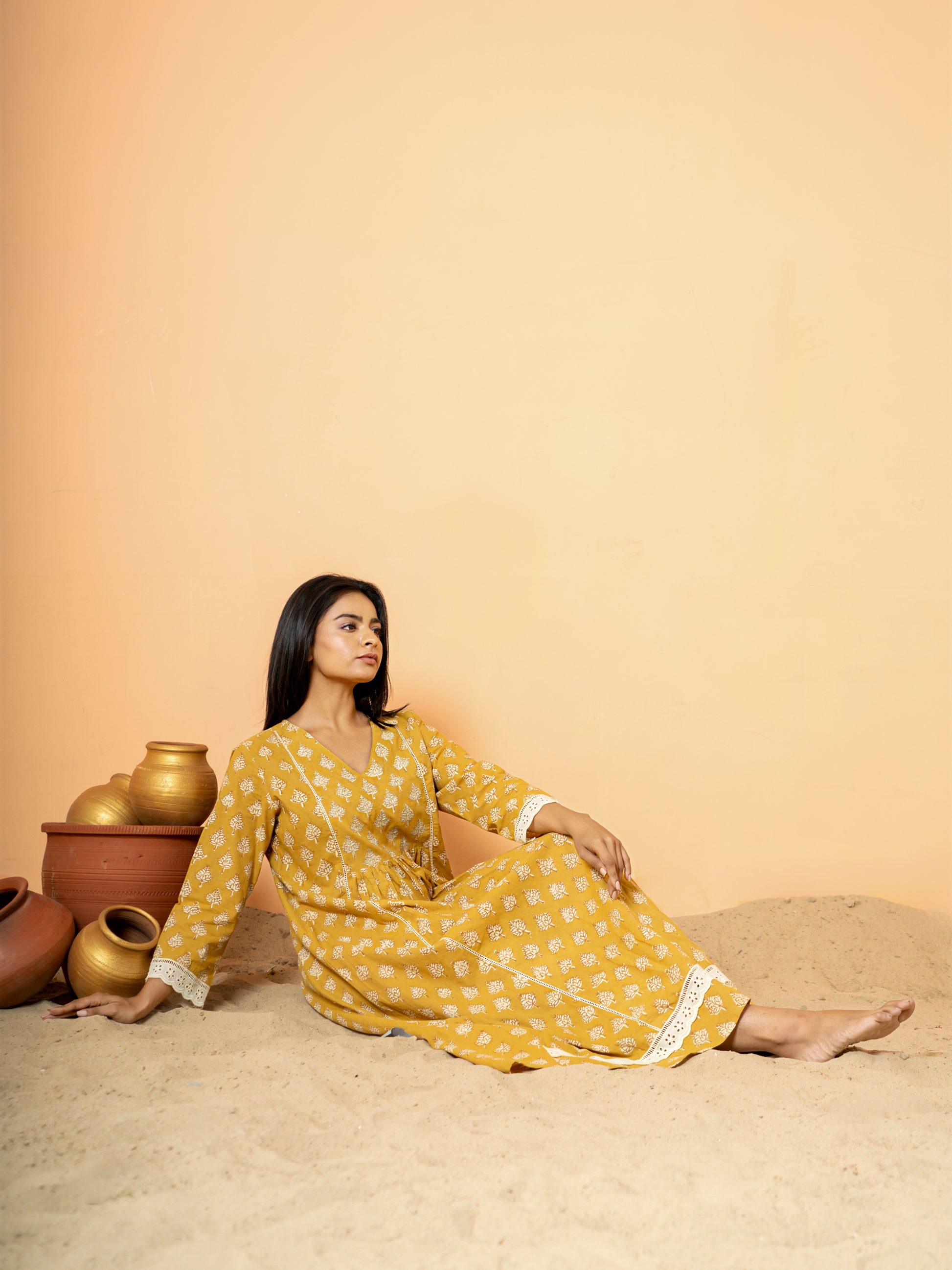 Detailed close-up focusing on the exquisite white lace work pattern along the rounded neckline of the mustard cotton kurta.