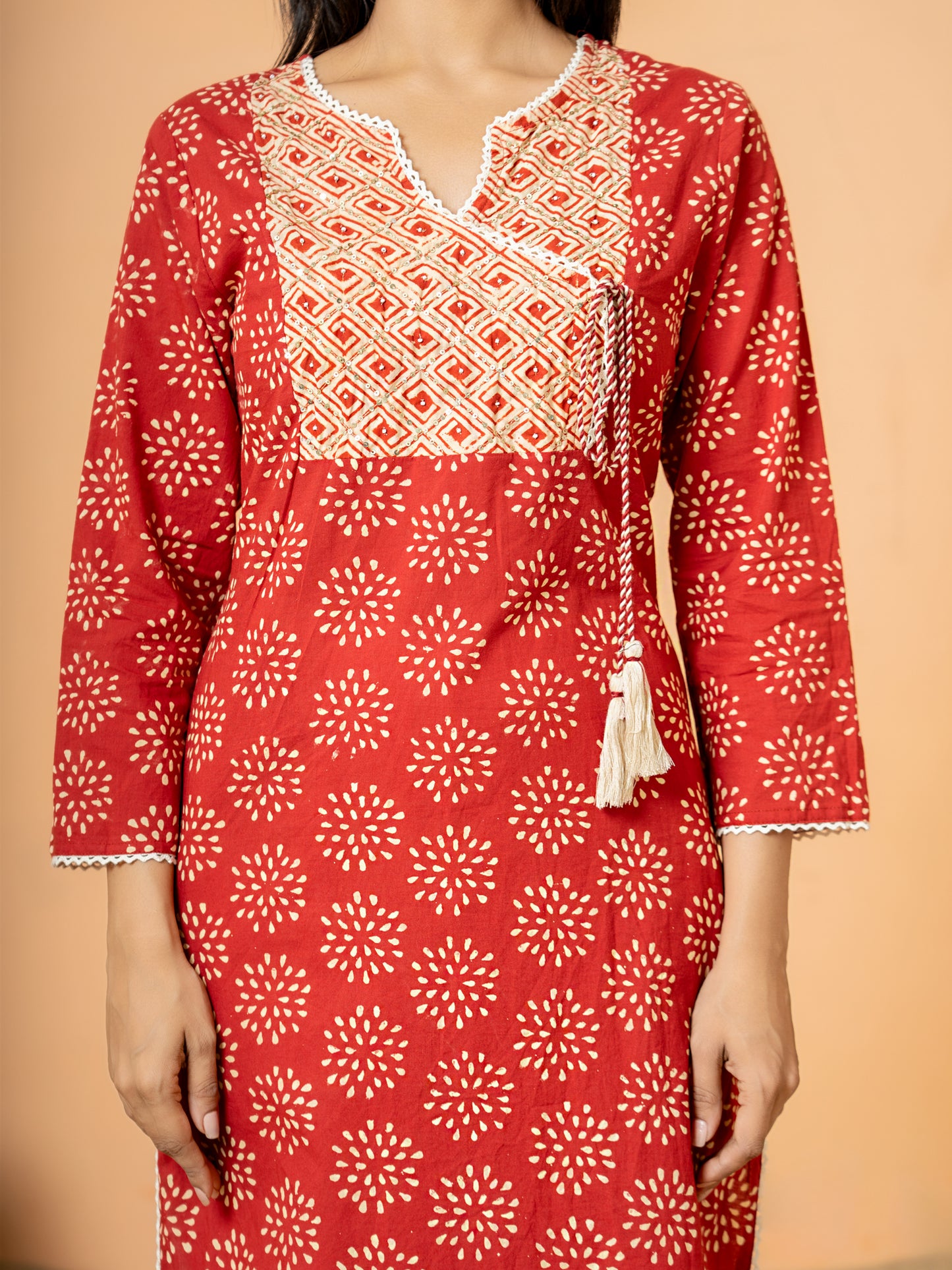 Detail image showing the classic round V neck style and 3/4th sleeves of the Red Embroidered Rangoli Print Cotton Kurta.