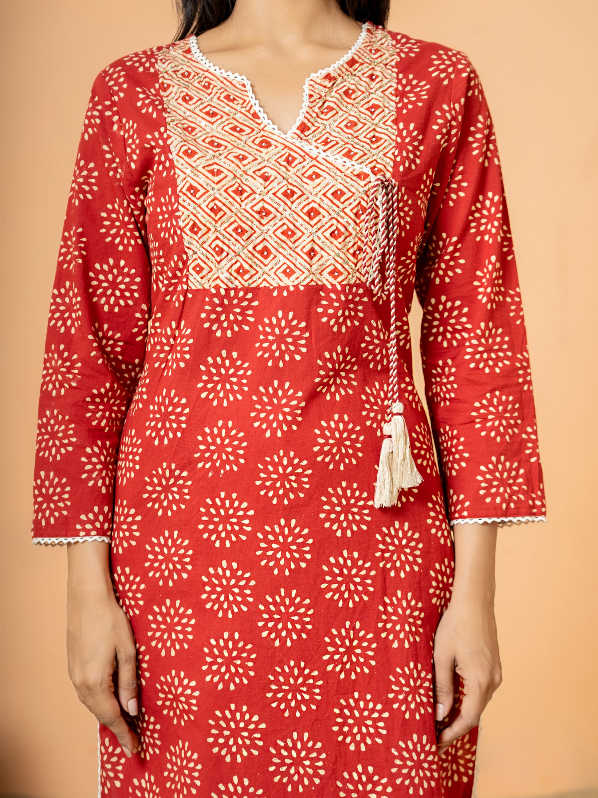 Detail image showing the classic round V neck style and 3/4th sleeves of the Red Embroidered Rangoli Print Cotton Kurta.
