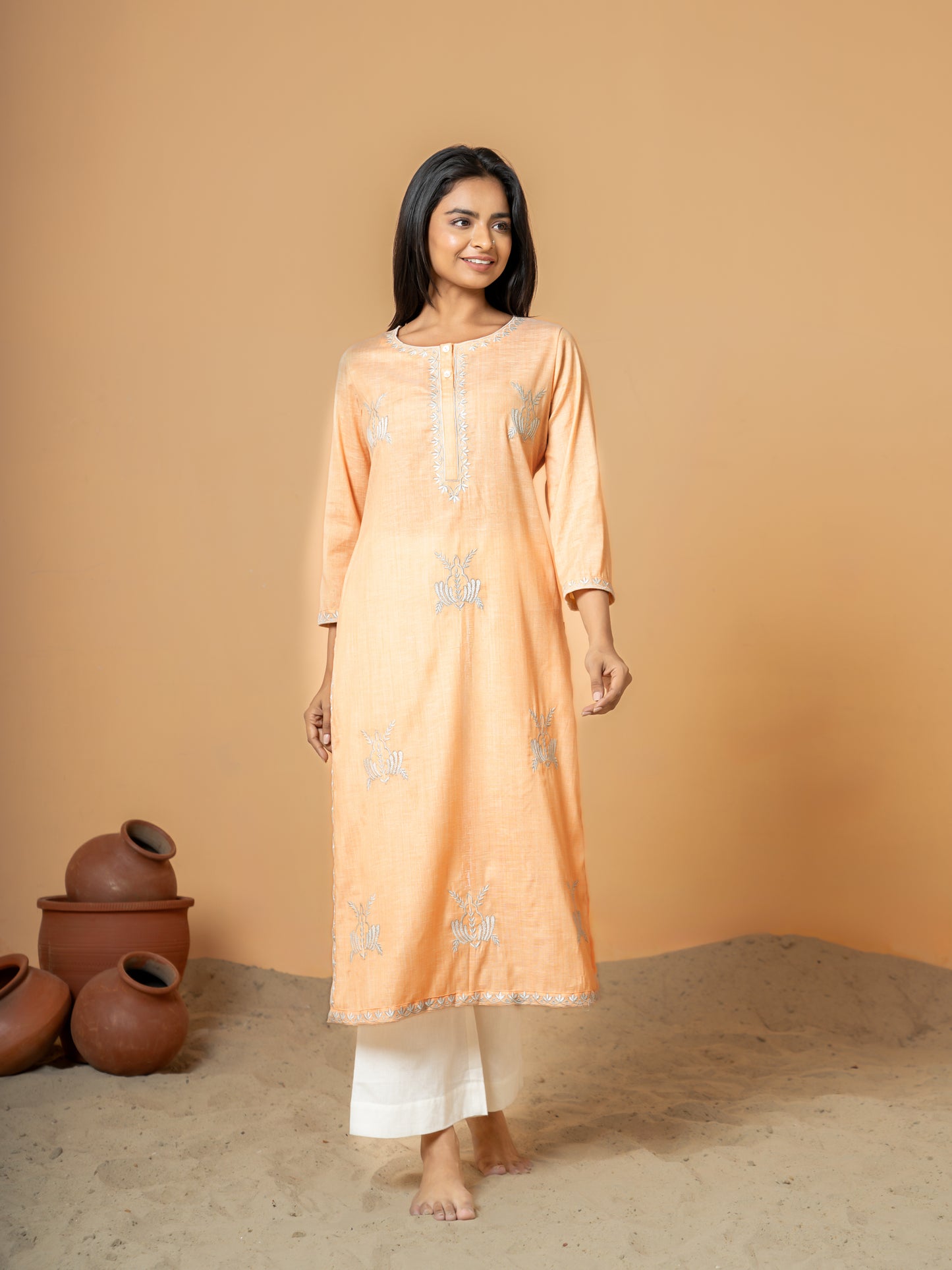 Full front view of the elegant Pastel Orange Embroidered Straight Cotton Kurta, showcasing intricate embroidery, classic round neck, and 3/4th sleeves on soft, pure cotton fabric.