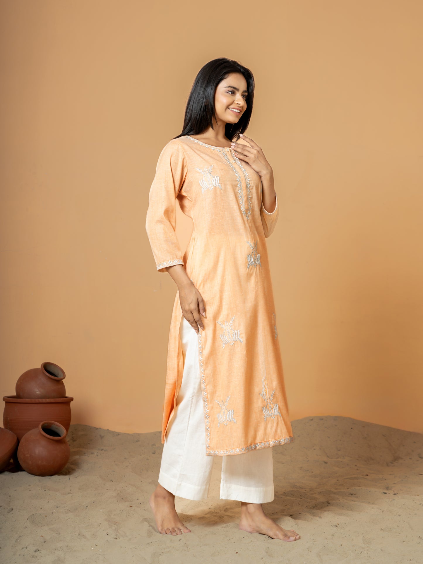 Image showing the full length and drape of the Pastel Orange Embroidered Straight Cotton Kurta, emphasizing its pure cotton comfort and elegant embroidered details.