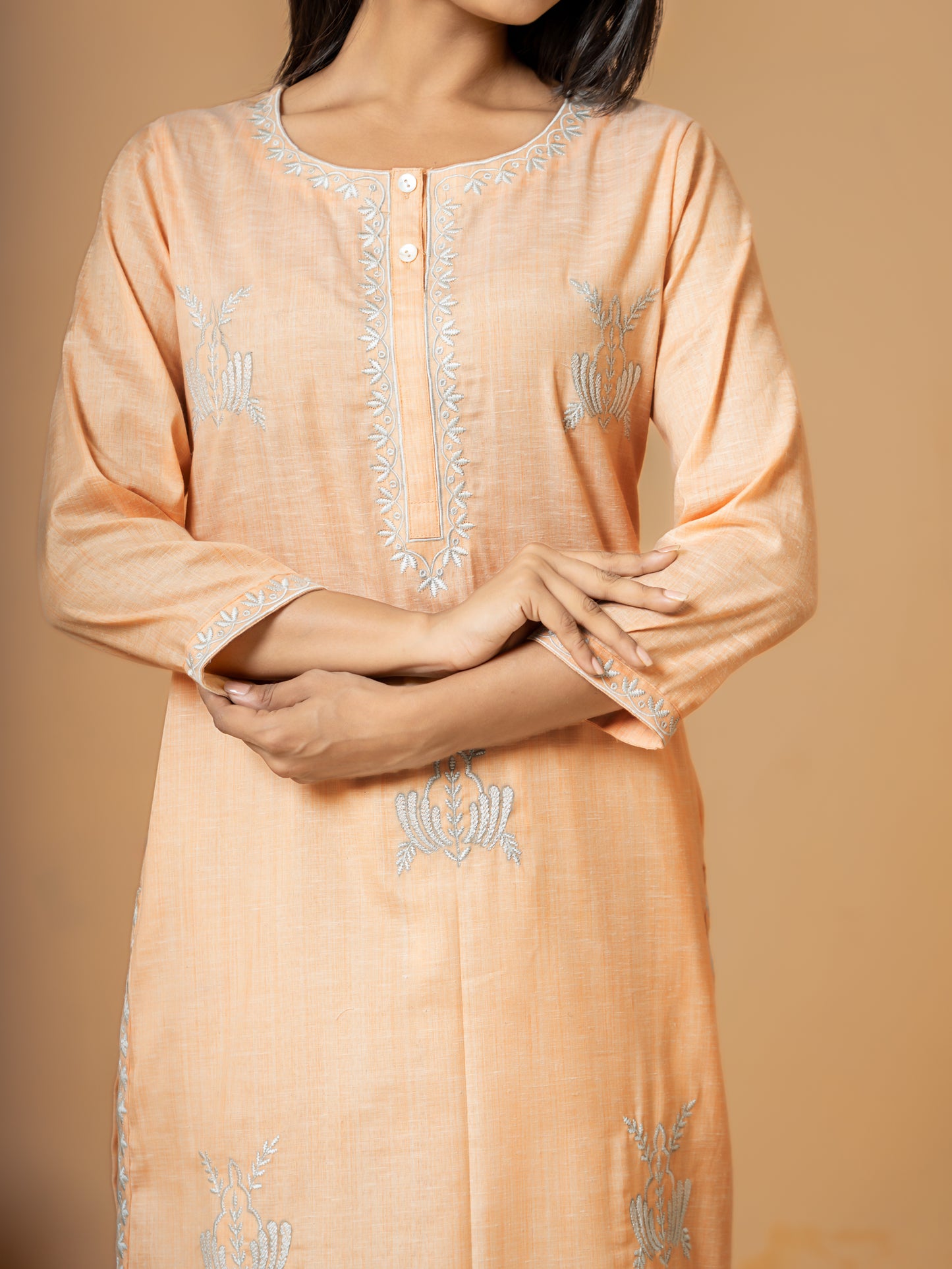 Close-up detail highlighting the delicate embroidery pattern on the soft, pure cotton fabric of the Pastel Orange Straight Cotton Kurta.