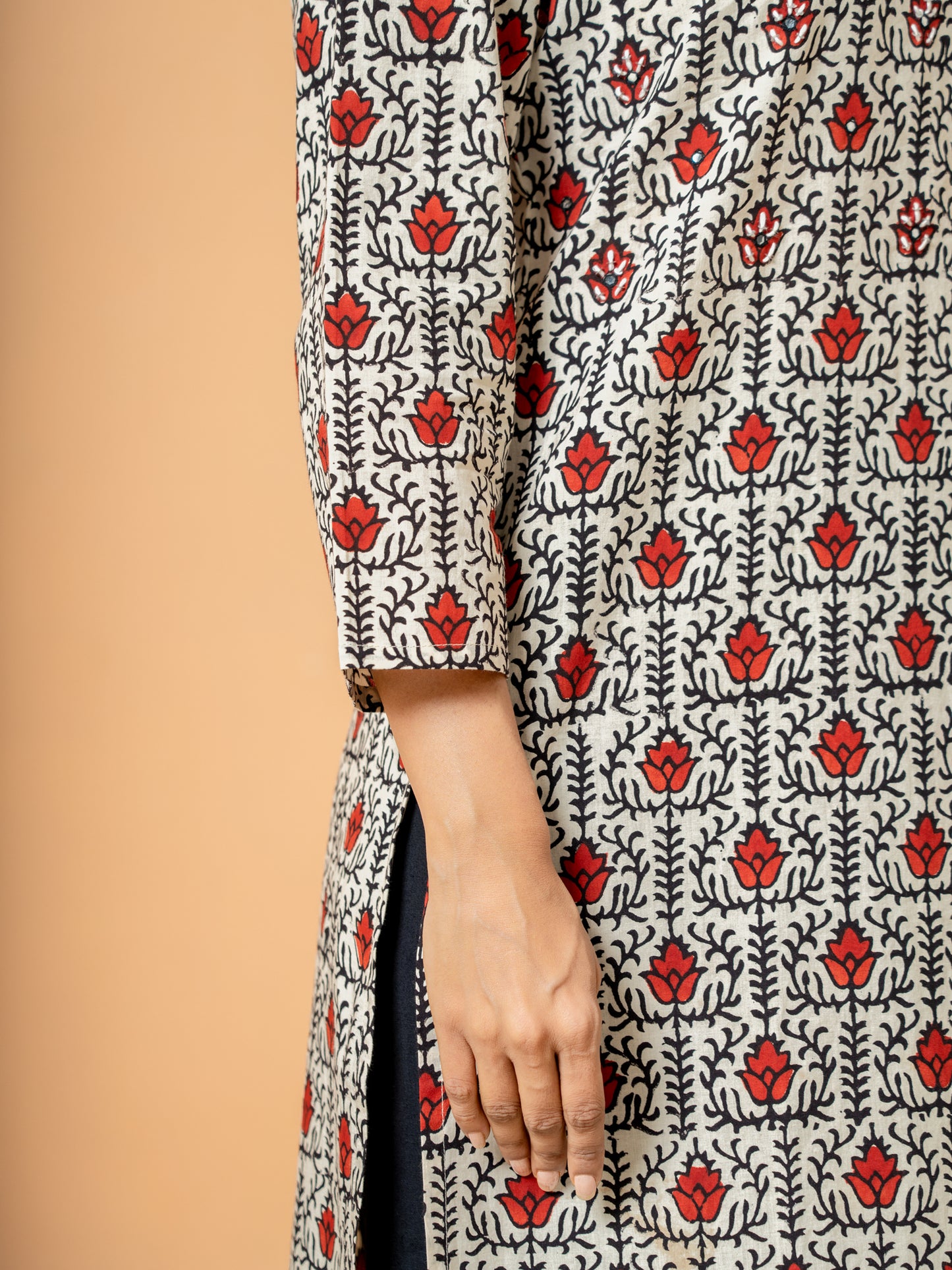 Close-up of the soft cream cotton fabric showing the intricate lotus handblock print design on the kurta.