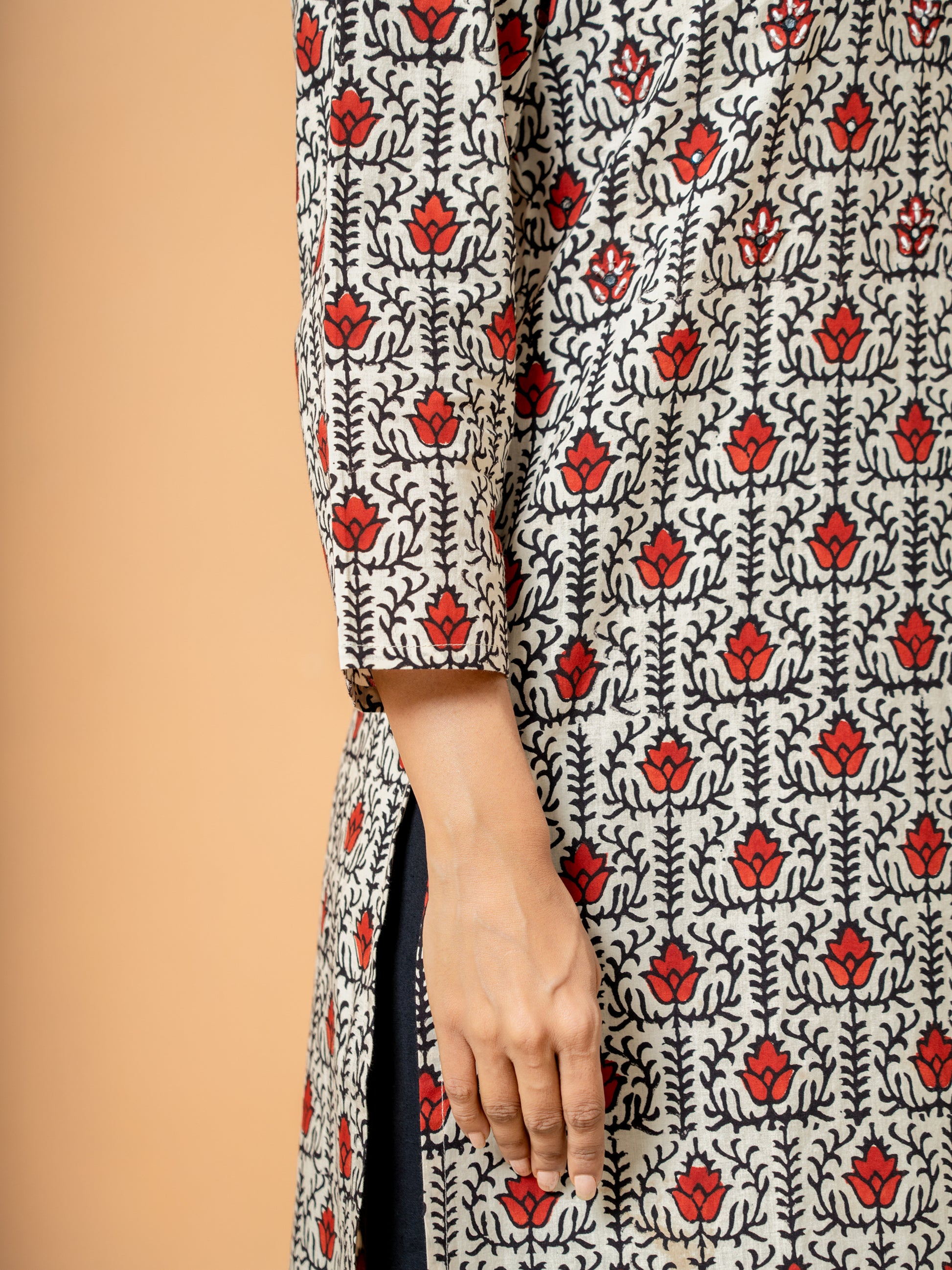 Close-up of the soft cream cotton fabric showing the intricate lotus handblock print design on the kurta.
