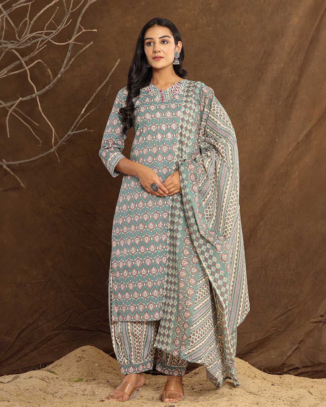 Front view of the Teal Leaf Printed Afghani Cotton Suit from Cottons Daily, featuring a grey kurta with teal leaf patterns, adorned with intricate embroidery and gotta patti foil work, paired with matching Afghani-style pants and a printed dupatta.