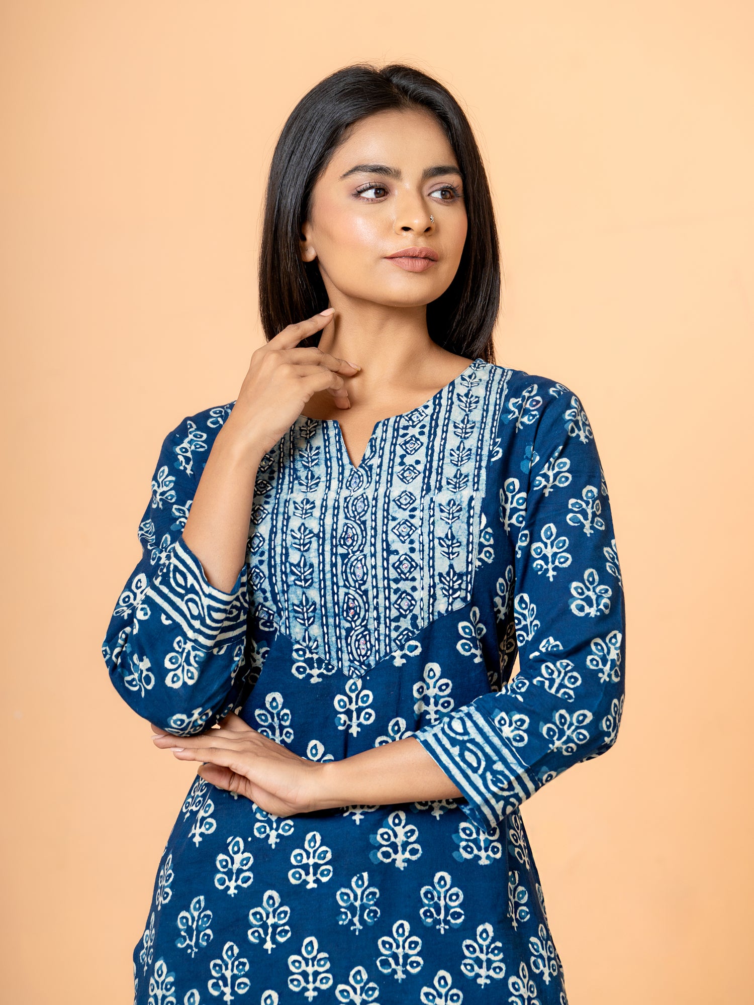Close-up detail showing the unique peacock feather print and sparkling sequence work on the indigo fabric of the Cotton Kurta.