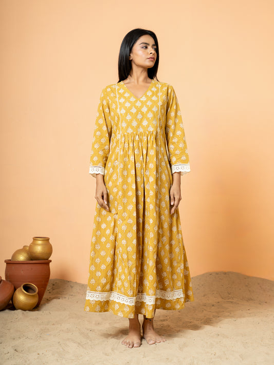 Full front view of a beautiful mustard yellow cotton kurta with intricate white lace work accentuating the neckline.